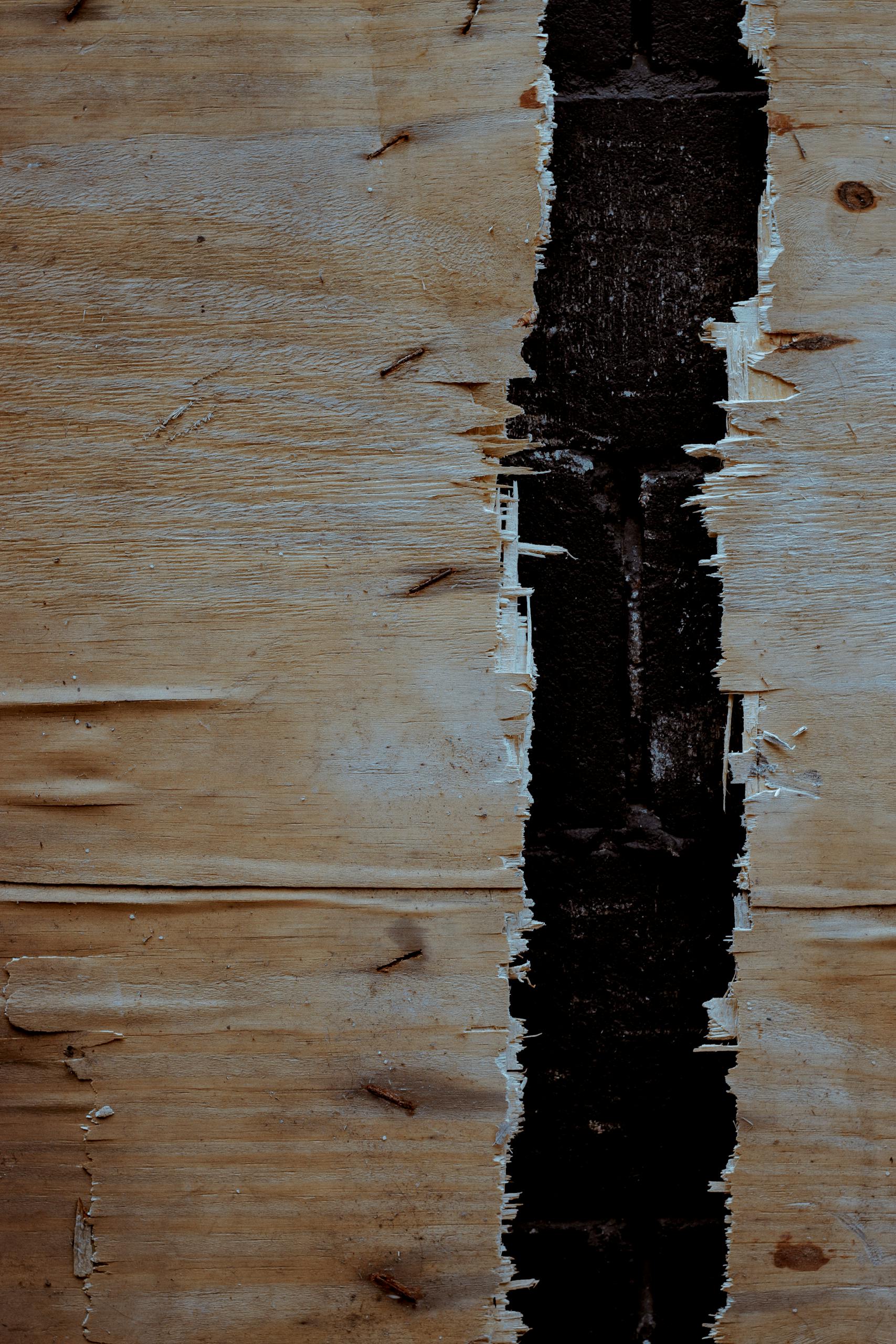 Close-up of a rough, rustic wooden surface with a distinctive dark gap.